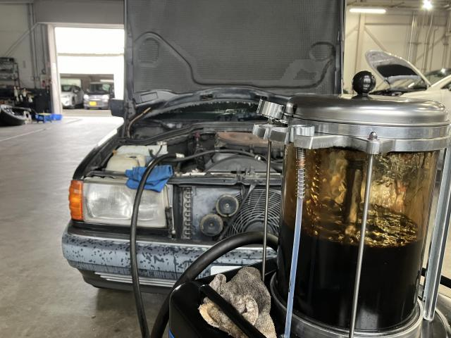 エンジンオイルを抜き取っている様子。オイルチェンジャーには黒く濁ったオイルが溜まっている