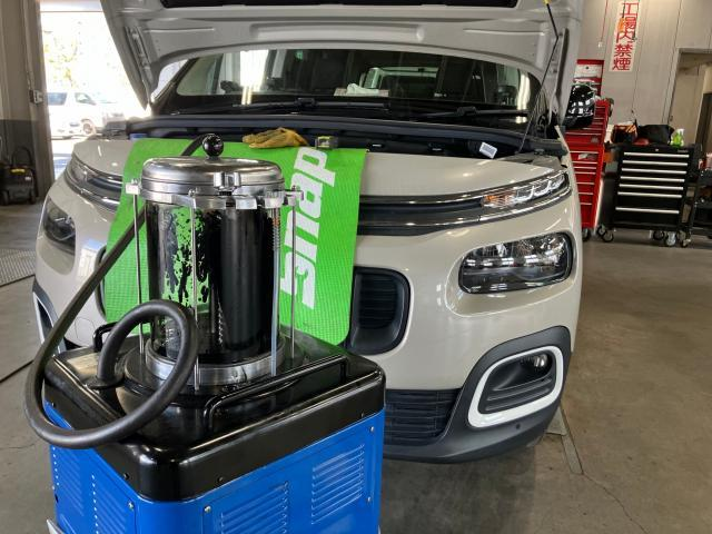 オイルチェンジャーを用いてオイル交換をしているベルランゴ